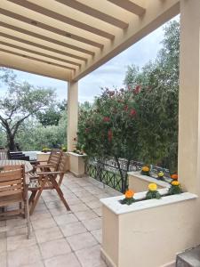 a patio with a table and chairs and a tree at Villa Elli in Limenas +14 photos