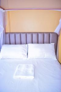 a large white bed with a purple head board at Lucci suites in Kisumu