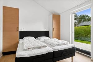 a bedroom with a bed with white sheets and a window at 30129-Odder-P-Baatrupsvej-29 in Odder