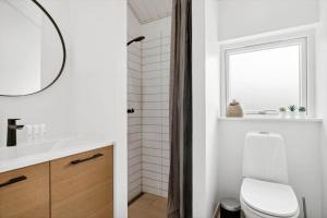 a bathroom with a white toilet and a window at 30129-Odder-P-Baatrupsvej-29 in Odder +25 photos