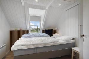 a bed in a white room with a window at 299-Ringkobing-Havklitvej-24 in Klegod