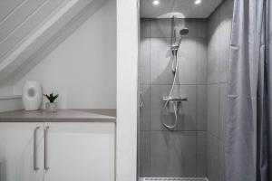 a bathroom with a shower with a shower curtain at 299-Ringkobing-Havklitvej-24 in Klegod +29 photos