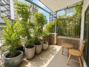 a balcony with a row of potted plants and a chair at Ben Thanh Hideaway - A Cozi Stay in Ho Chi Minh City