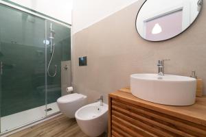 a bathroom with a sink and a toilet and a mirror at Velis - art & hospitality in Posada +64 photos