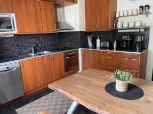 a kitchen with wooden cabinets and a wooden table at Yyterin Meriheinä in Pori