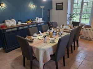 a dining room with a long table and chairs at La Rivetière in Courcemont