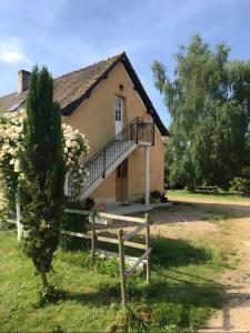 a house with a staircase in front of it at La Rivetière in Courcemont
