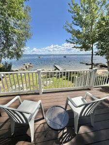 two chairs and a table on a deck overlooking the water at ROCKY BEACH LIMIT 5 cabin in Standish