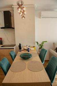 a dining room table with a green plate on it at RIVER VIEW & Private Parking - Baia Mare in Baia Mare