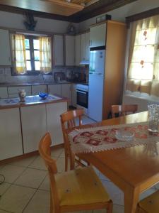 a kitchen with a table and chairs and a refrigerator at Theasi in Konitsa