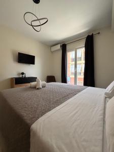 a bedroom with a large white bed and a window at Ionian Port Suite in Ágios Rókkos