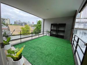 a balcony with green flooring on a building at Home Sukhumvit 49 Soi 14 in Bangkok