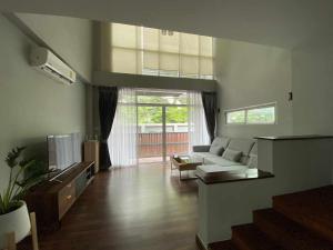 a living room with a couch and a tv at Home Sukhumvit 49 Soi 14 in Bangkok