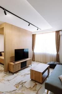 a living room with a television and a marble floor at Gallus Inn in Aleksinac
