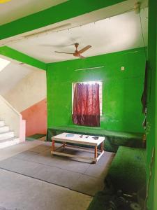 a green room with a table in front of a window at HR home stay in Chennai