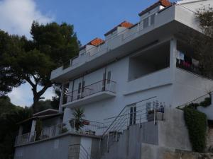 a white building with balconies and a tree at Nature sunset apartment in Ubli