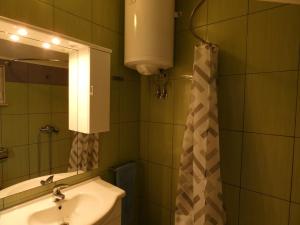 a bathroom with a sink and a mirror at Nature sunset apartment in Ubli +20 photos
