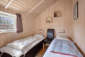 a room with two beds and a chair and a window at FY187-Asperup-Bogevangsvej-1 in Asperup
