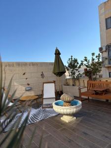 a patio with a fountain and an umbrella at Melita Living in Sliema
