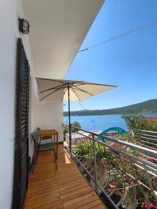 a balcony with a table and an umbrella at Apartments PODATOK 4 in Primošten