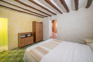a bedroom with a white bed and a wooden dresser at San José Moratalla in Moratalla