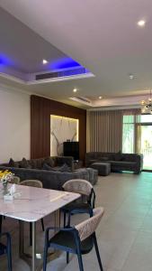 a living room with a couch and a table and chairs at فيلا درة العروس 2 in Durat Alarous