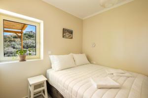a small bedroom with a white bed and a window at Sunrise apartments in Menetaí
