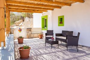 a patio with black chairs and a table at Sunrise apartments in Menetaí