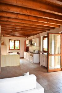 a large kitchen with wooden ceilings and a white couch at Residence La Pineta in Serina