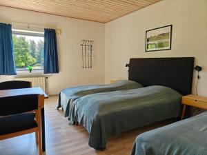 a bedroom with two beds and a window at Nordgården Pension in Onsbjerg