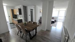 a dining room and living room with a table and chairs at Stan na dan Tuzla in Tuzla