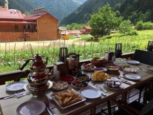 a table with plates of food and a kettle on it at Çakıroğlu Villa Kent Pansiyon in Uzungöl