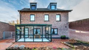 a glass house in front of a brick building at Haus Jansen in Korschenbroich