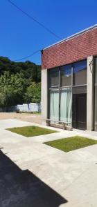 a brick building with a window with a curtain at Hotel in Surami