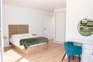 a bedroom with a bed and a desk at Pérola de São João in Calheta +37 photos