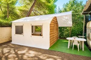 a small white play house with a table and a chair at XeniCamp & Bungalows in Tolo