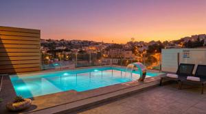 a swimming pool on the roof of a building at Maltese Luxury Villas - Sunset Infinity Pools, Indoor Heated Pools and More! in Mellieħa