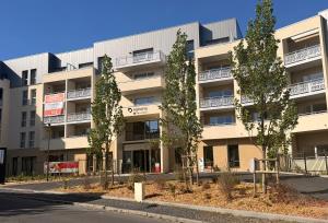 an apartment building with trees in front of it at DOMITYS - L'Alezane in Saint Lo