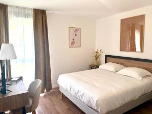 a bedroom with a bed and a desk and a window at DOMITYS - L'Alezane in Saint Lo +9 photos