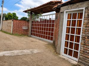 a brick building with a door and a fence at Finca fercho rozo in Rozo