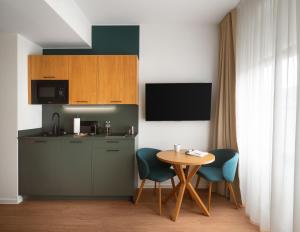 a kitchen with a table and two chairs and a table at Limehome Berlin Klosterstraße in Berlin