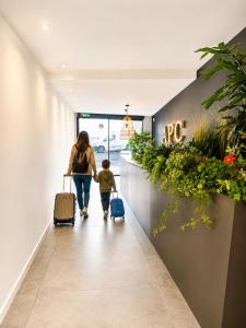 a woman and child walking down a hallway with luggage at Apartaments Turístics Conseller in Andorra la Vella