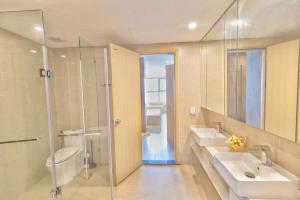 a bathroom with two sinks and a glass shower at The Song Vung Tau Apartment - Căn Hộ Du Lịch Biển Vũng Tàu in Xã Thang Tam +63 photos