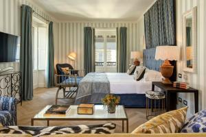 a hotel room with a bed and a living room at Rocco Forte Hotel Savoy in Florence