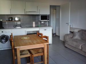 a kitchen and dining room with a table and a couch at T2 Château vert in Le Grau-dʼAgde +2 photos