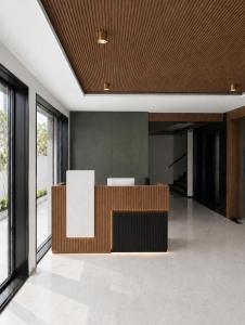 an office lobby with a reception desk and windows at Arthana Grand Inn in Udumalaippettai