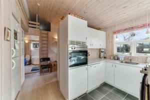 a kitchen with white cabinets and a stove top oven at 30035-Malling-Pilelokken-16 in Malling