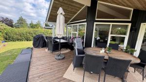 a wooden deck with a table and chairs and an umbrella at 30035-Malling-Pilelokken-16 in Malling