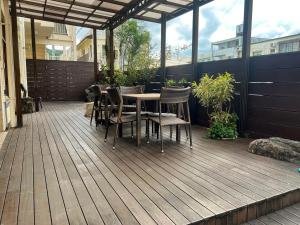 a patio with a table and chairs on a deck at Hotel Yamadaso in Nago