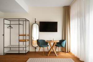 a living room with a table and chairs and a shelf at Limehome Berlin Klosterstraße in Berlin